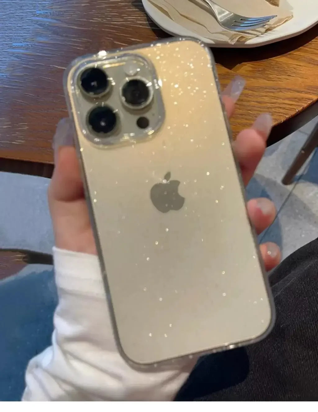 Phone with a reflective case held by a person in a casual setting