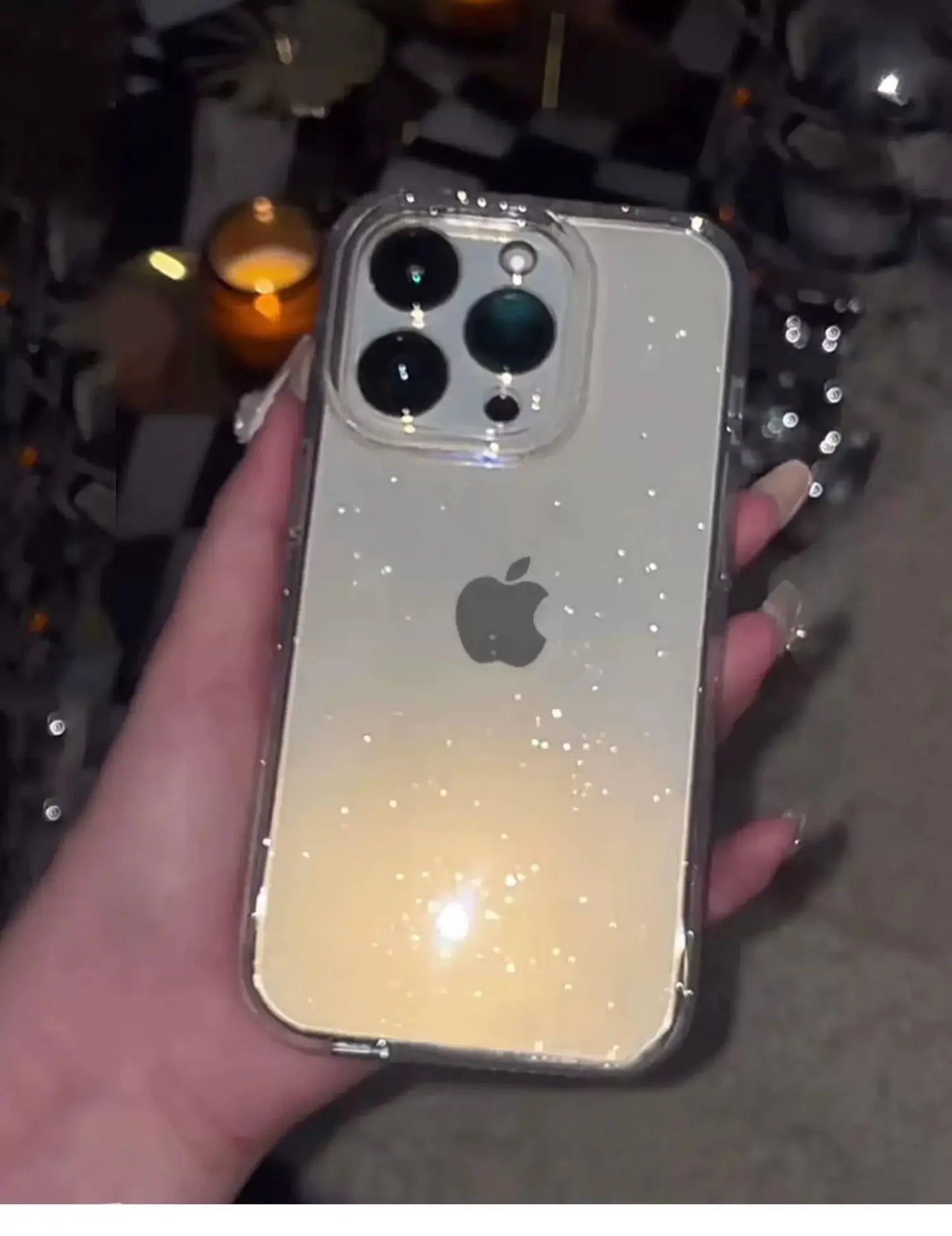 Hand holding a smartphone with a glittery case against a blurred background