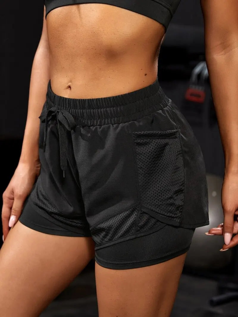 Black athletic shorts worn by a person with a blurred background