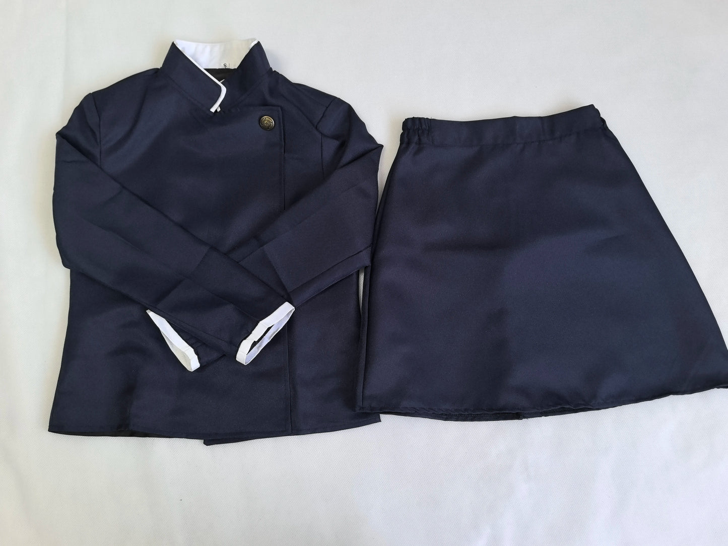 Navy blue jacket and skirt set on a white background