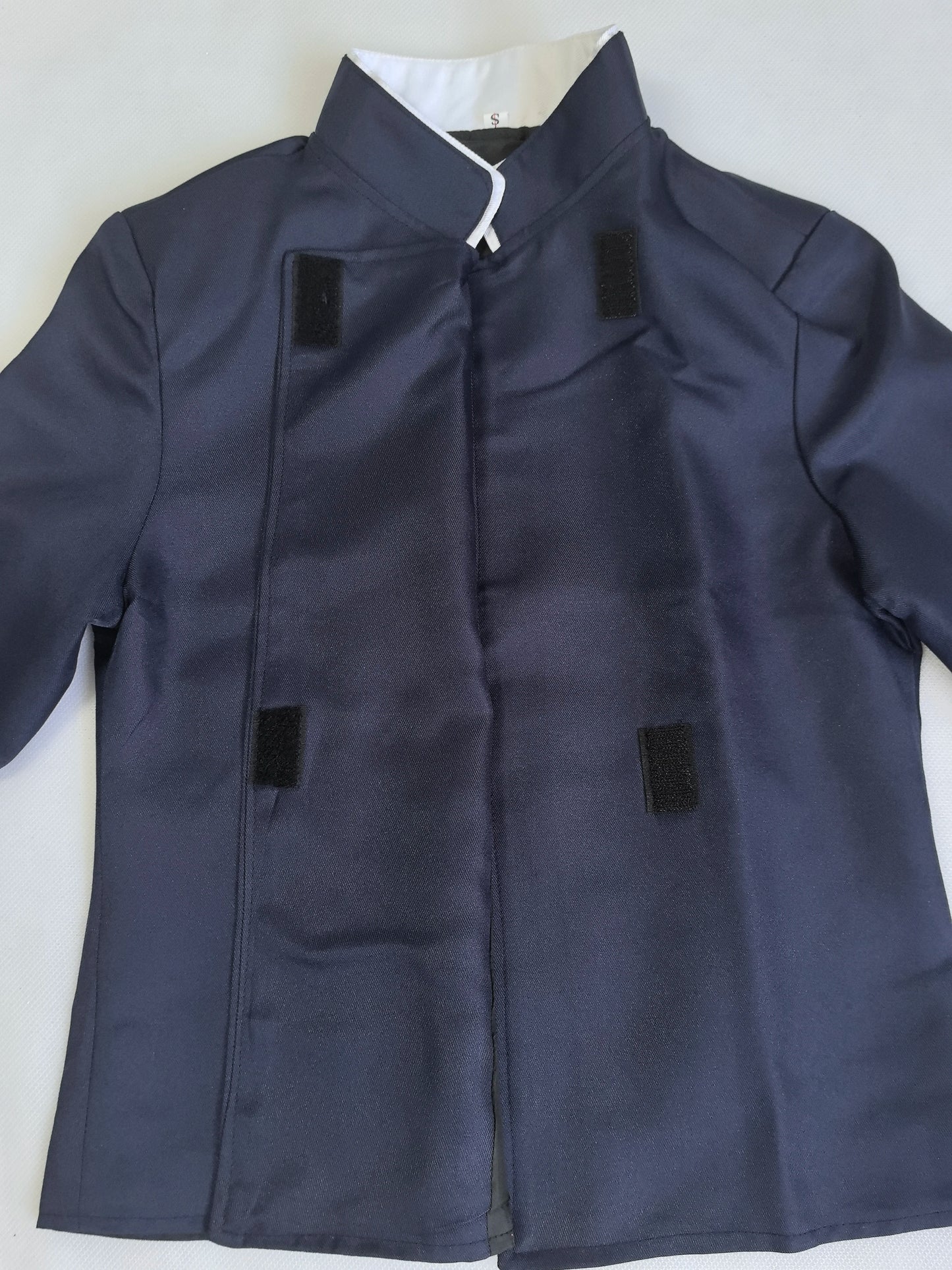 Dark blue coat with black patches on a white background