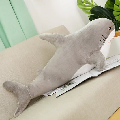 Plush shark toy on a couch with a magazine underneath