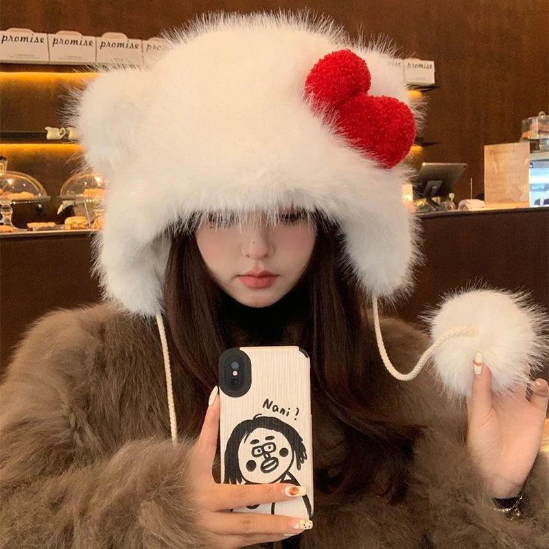 Person wearing a fluffy white hat with red pom-poms, holding a phone with a cartoon case.