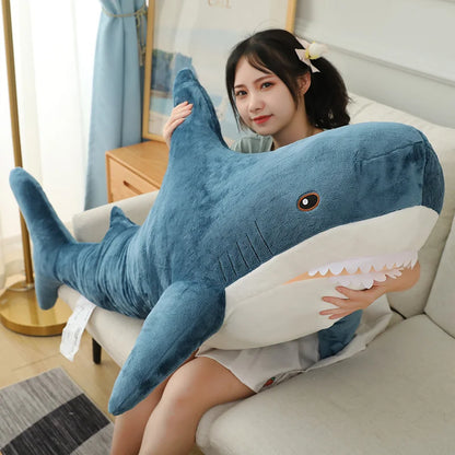 Person holding a large shark-shaped pillow on a couch