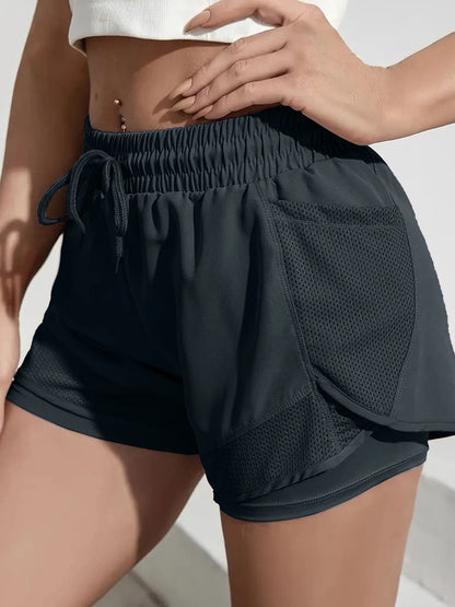 Black athletic shorts with a pocket on a neutral background