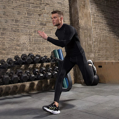 Man in black athletic wear performing a lunge in a gym setting with weights and a ball in the background.