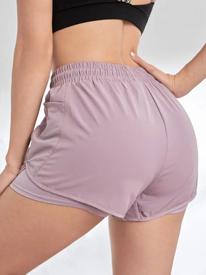 Person wearing mauve athletic shorts on a plain background