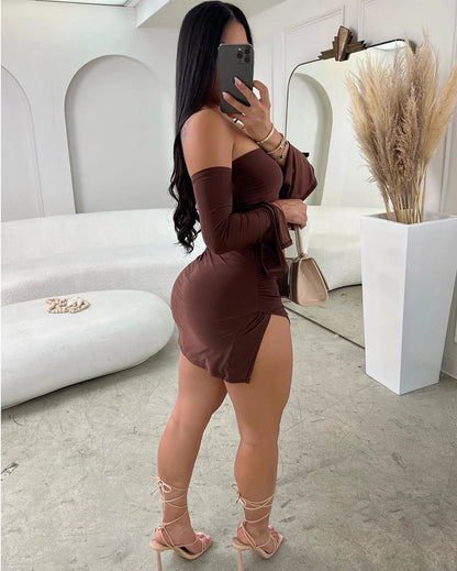 Woman in a brown dress taking a mirror selfie in a stylish room.