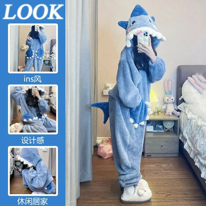 Person wearing a blue shark-themed onesie in a bedroom setting.