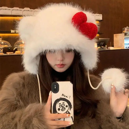 Person wearing a fluffy white hat with red pom-poms, holding a phone with a cartoon case.