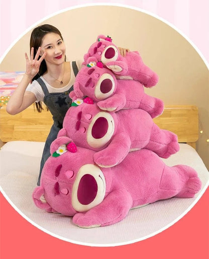 Stack of pink plush toys resembling bears with a person next to them on a light-colored surface.