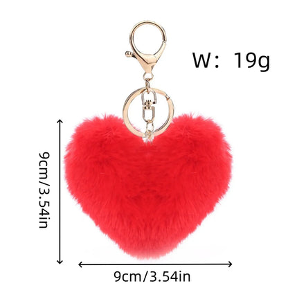 Red heart-shaped fluffy keychain with gold ring and measurements on a white background