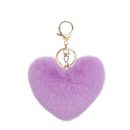 Purple heart-shaped fluffy keychain with a gold clasp on a white background