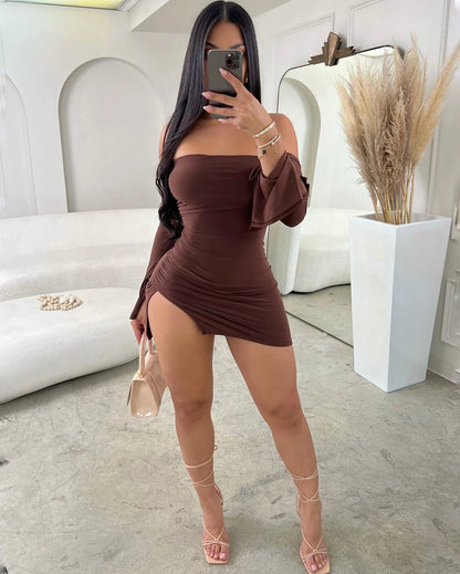 Woman taking a mirror selfie wearing a brown off-shoulder dress in a modern interior setting.