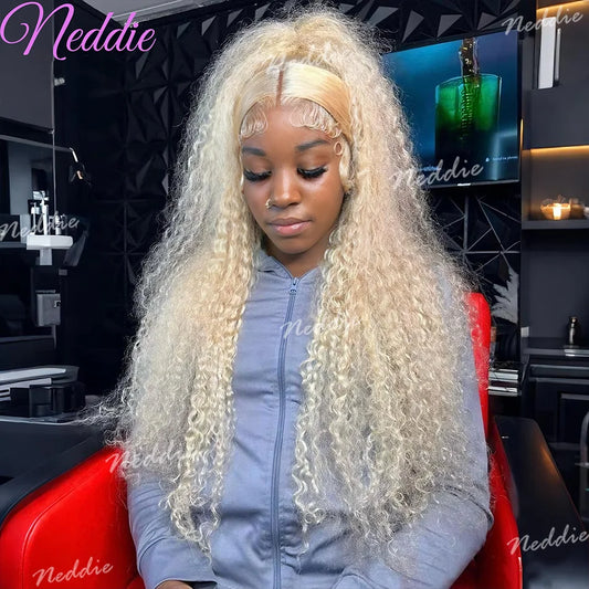 Person with long blonde hair sitting in a salon chair, wearing a gray hoodie with 'Neddie' branding.