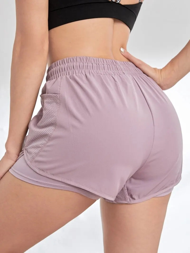 Person wearing mauve athletic shorts on a plain background