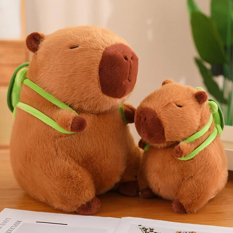 Two brown teddy bears with green straps on a wooden surface.