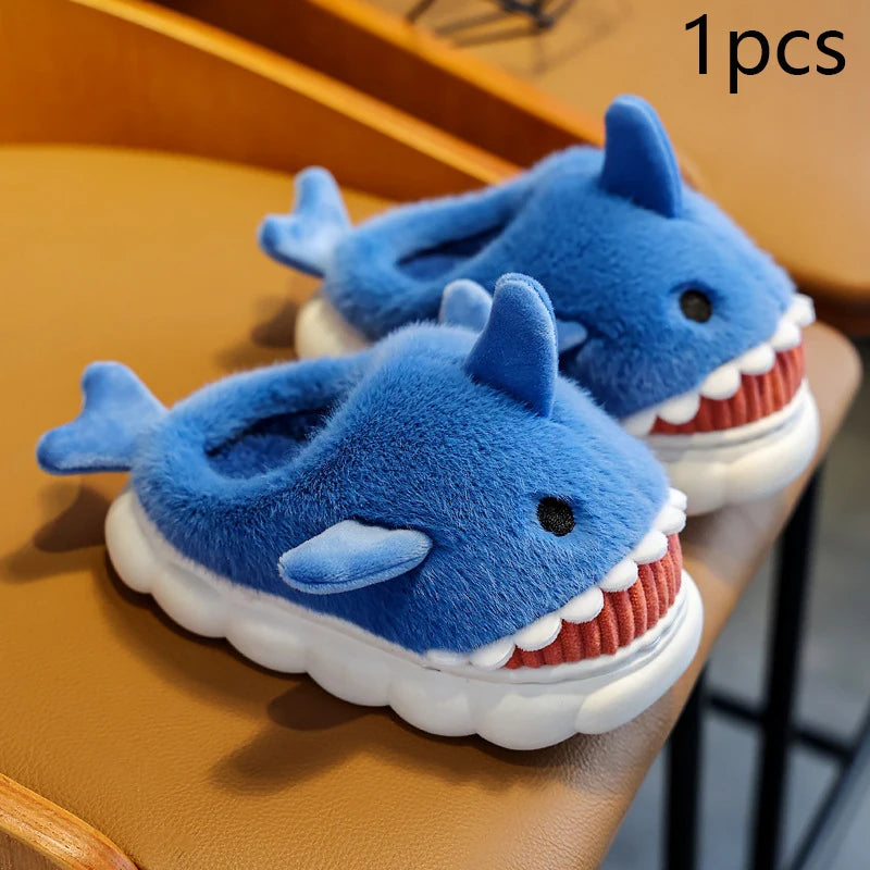 Pair of blue shark-shaped slippers on a wooden surface.
