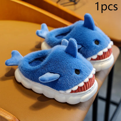 Pair of blue shark-shaped slippers on a wooden surface.
