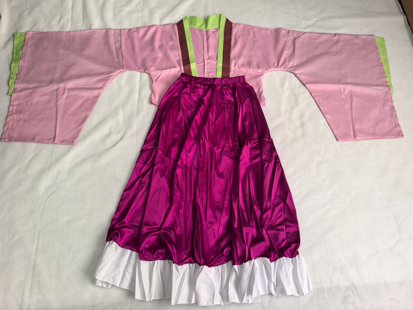 Traditional outfit with pink top and purple skirt on a white background