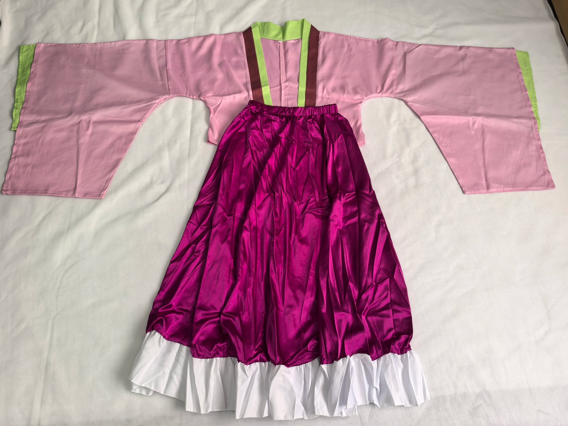 Traditional outfit with pink top and purple skirt on a white background