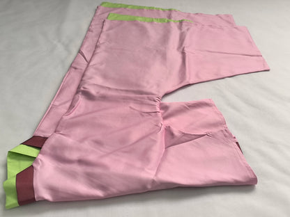 Pink fabric with green and brown accents on a light gray background