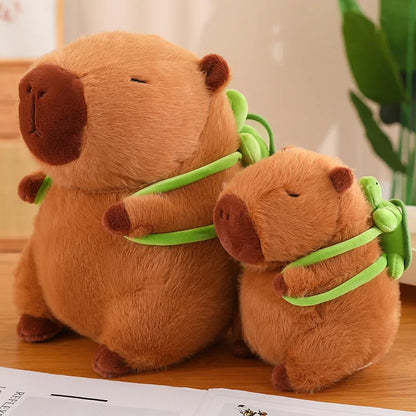 Two brown plush animals with green ribbons on a wooden surface.