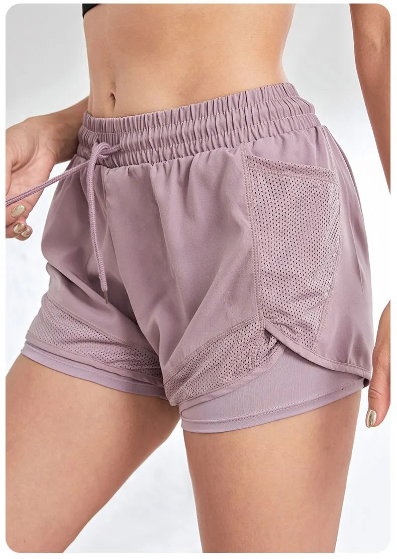 Light purple athletic shorts with mesh panels on a white background
