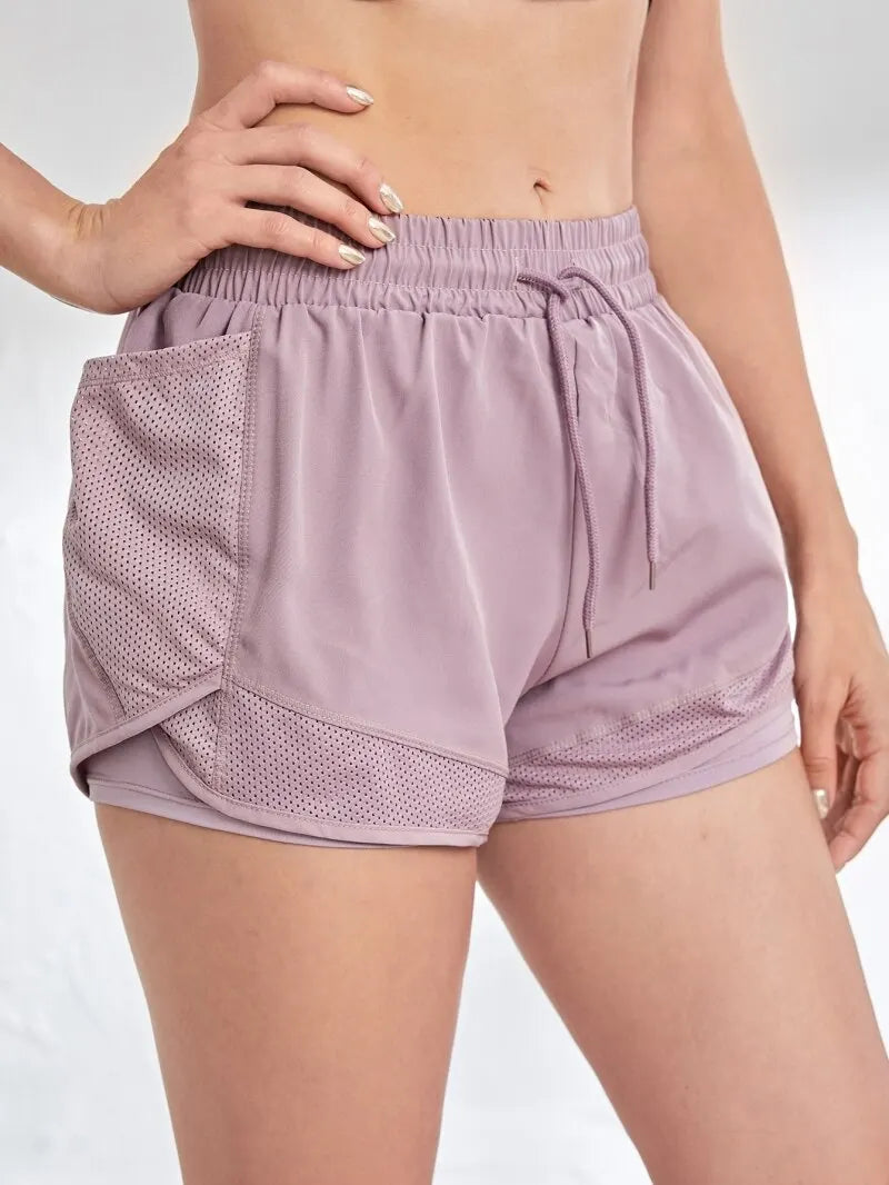 Light purple athletic shorts with mesh panels on a white background
