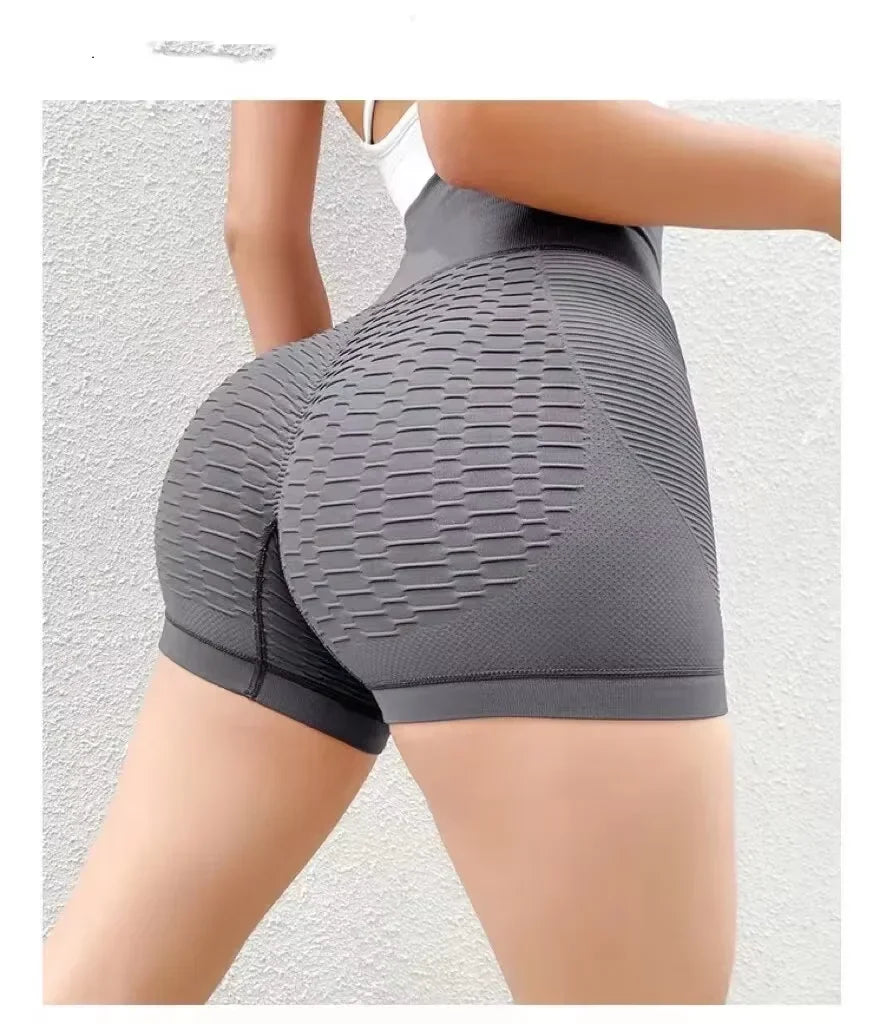 Gray compression shorts being worn on a plain background