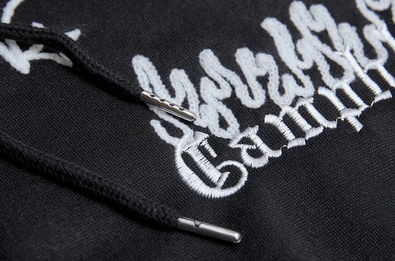 Black hoodie with white embroidered text and logo on a dark background