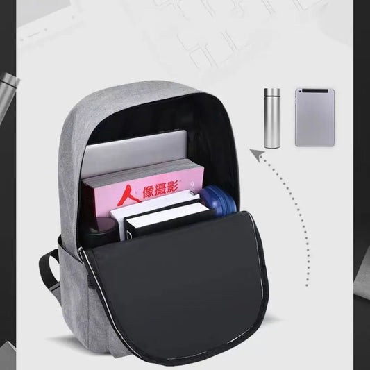 Gray backpack with compartments containing a laptop, books, and a water bottle on a white background.
