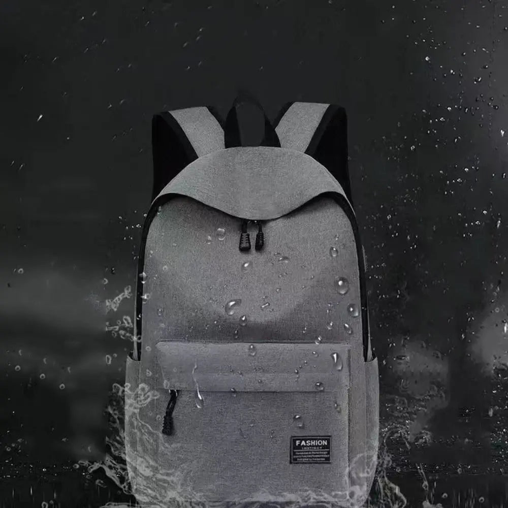 Gray backpack with water droplets on a dark background