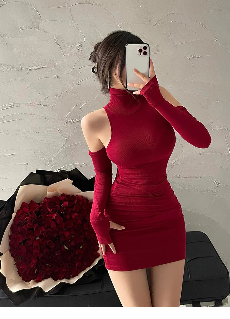 Person wearing a red dress with long sleeves in front of a bouquet of red roses.