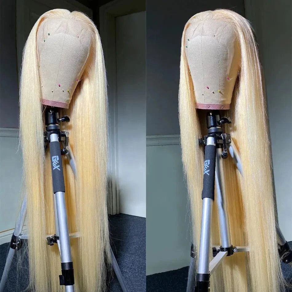 Blonde wig on a mannequin head with a stand against a neutral background