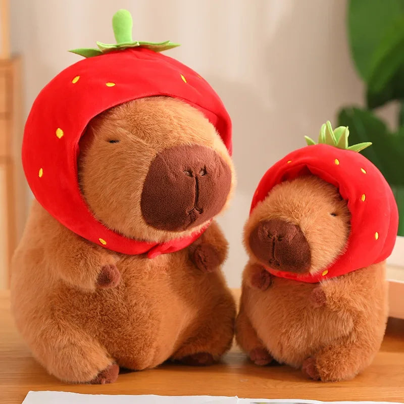Two plush toys resembling bears wearing strawberry hats on a wooden surface.