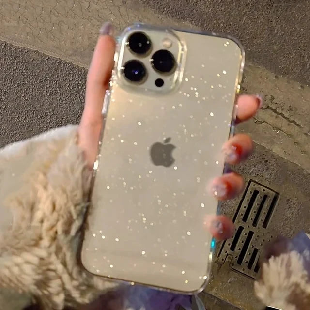 Phone with glittery case held by a person with pink nail polish.