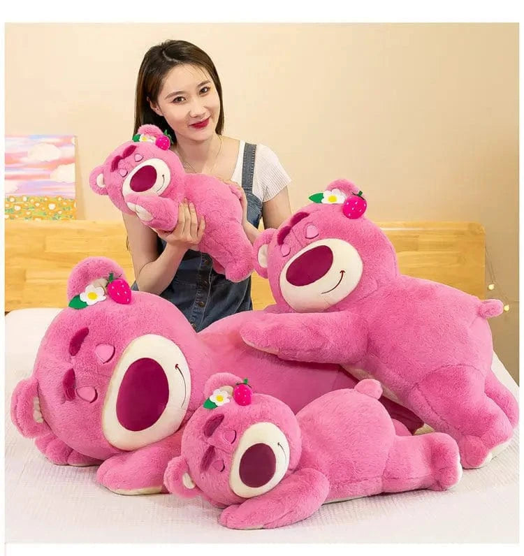 Woman holding a pink plush toy with a smiley face on a bed