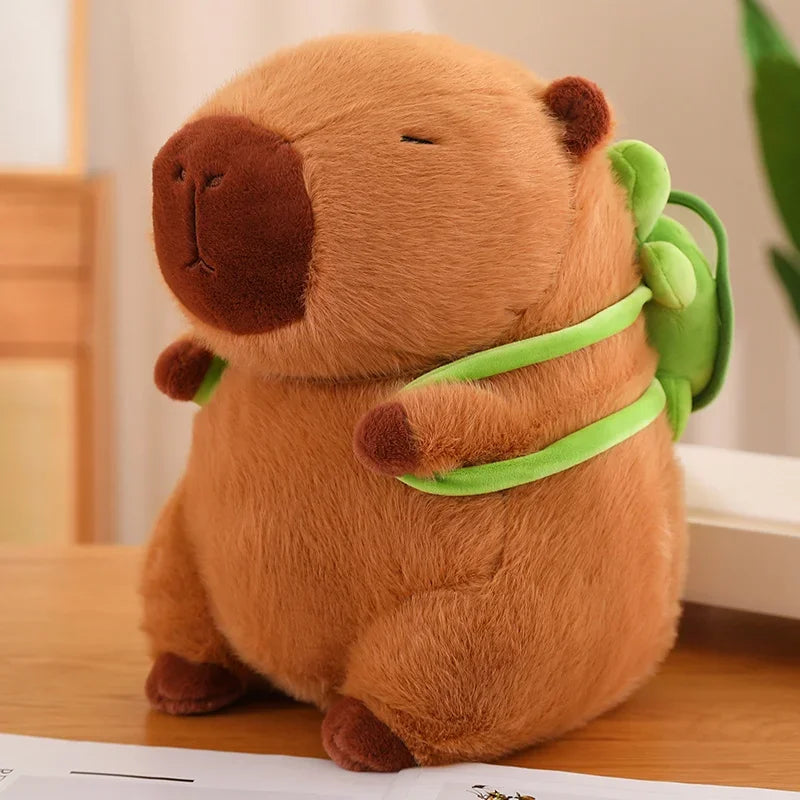 Plush toy resembling a beaver with a green leaf on a wooden surface