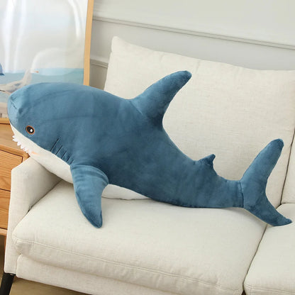 Blue shark-shaped pillow on a beige couch
