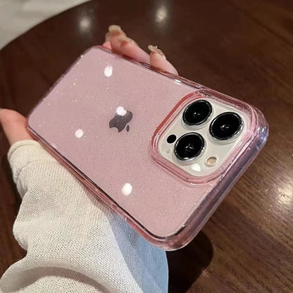 Pink glittery phone case with Apple logo held by a person on a wooden surface