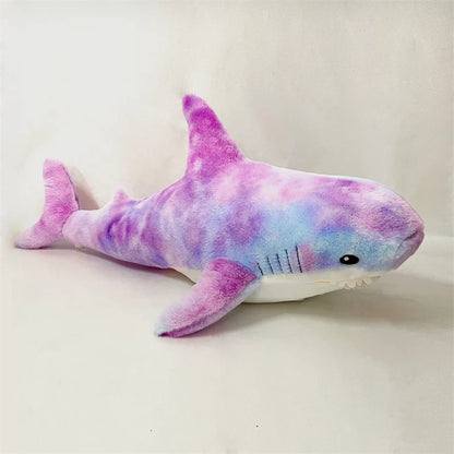 Plush shark toy with a tie-dye pattern on a white background