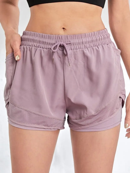 Purple athletic shorts worn by a person on a plain background