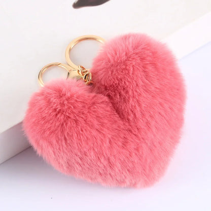 Pink fluffy heart-shaped keychain on a white background