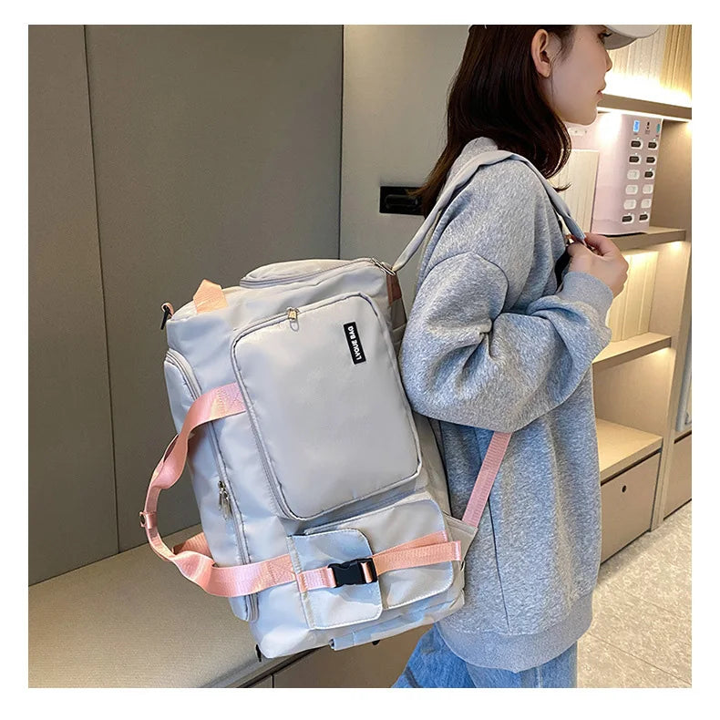 Person wearing a light blue backpack with pink straps in an indoor setting