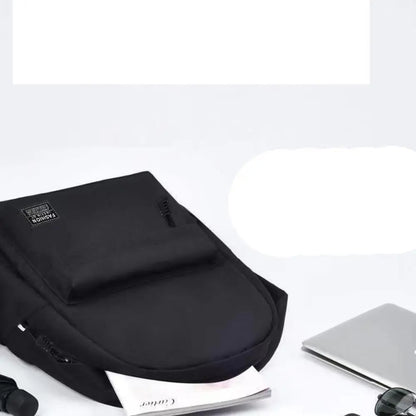Black backpack on a white surface with a laptop and other items.