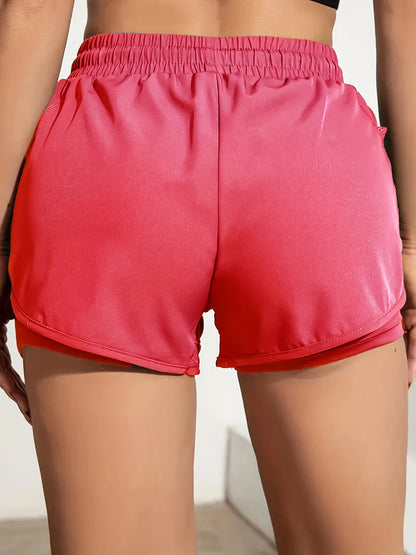 Person wearing bright pink shorts on a neutral background