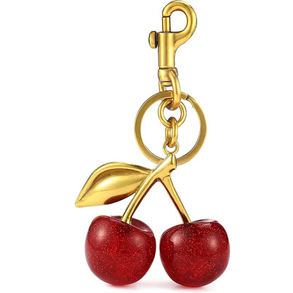Gold keychain with red cherries on a white background