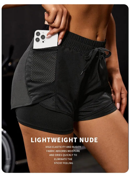 Person wearing black athletic shorts with a pocket holding a phone, against a dark background.
