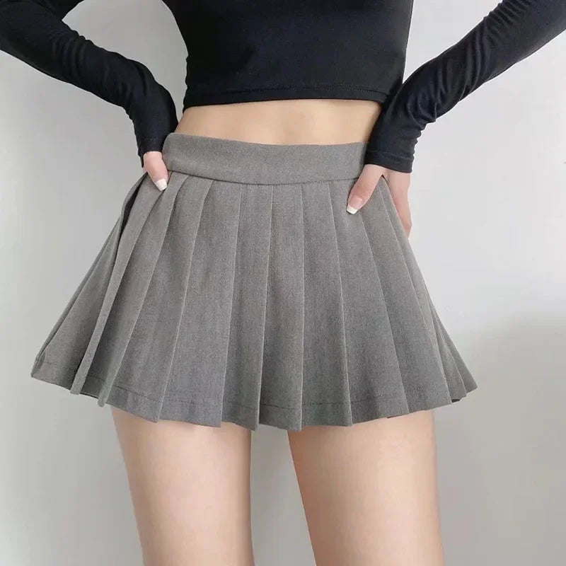 Gray pleated skirt worn by a person against a plain background